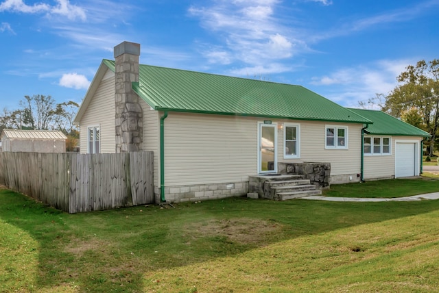 back of property with a garage and a yard