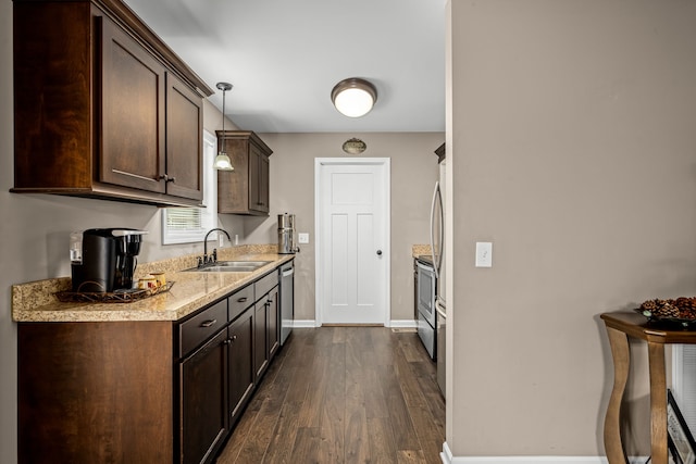 kitchen with dark wood-type flooring, sink, dark brown cabinets, pendant lighting, and appliances with stainless steel finishes