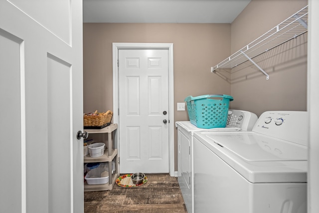 clothes washing area featuring dark wood-type flooring and washer and clothes dryer