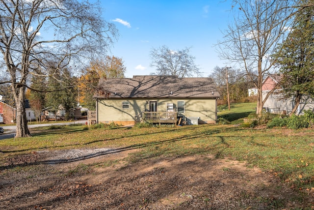 back of house featuring a wooden deck and a yard