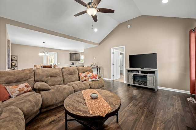 living room with ceiling fan with notable chandelier, dark wood-type flooring, and vaulted ceiling