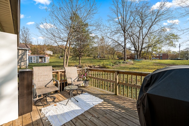 wooden terrace with a lawn and area for grilling