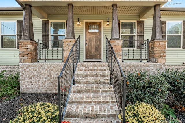 view of exterior entry featuring covered porch