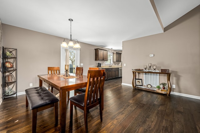 dining space featuring dark wood-type flooring, a chandelier, and sink