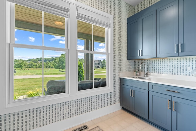 5124 Bond Mill Rd, Thompsons Station, TN 37179 - kitchen featuring a sink, wallpapered walls, light countertops, blue cabinets, and baseboards