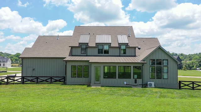 rear view of property featuring a standing seam roof, fence, board and batten siding, and a yard