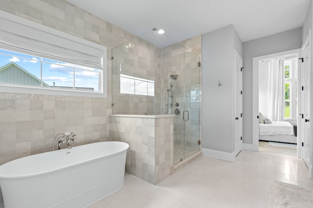 ensuite bathroom with a healthy amount of sunlight, a shower stall, a freestanding bath, and ensuite bathroom