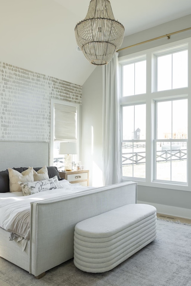 bedroom featuring high vaulted ceiling, multiple windows, and a notable chandelier