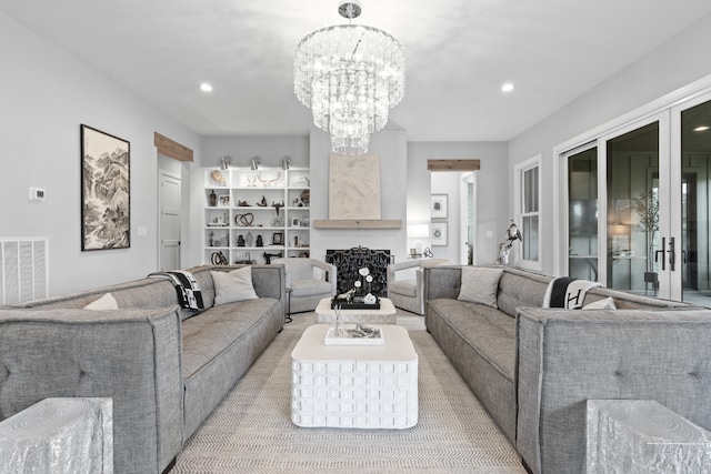 living room featuring recessed lighting, a fireplace, visible vents, and a notable chandelier