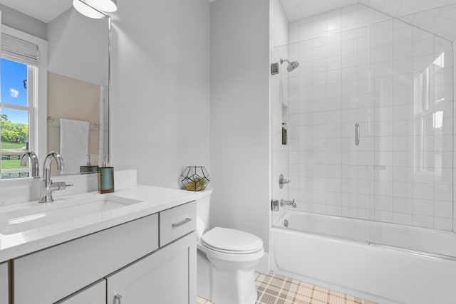 bathroom with toilet, vanity, and enclosed tub / shower combo