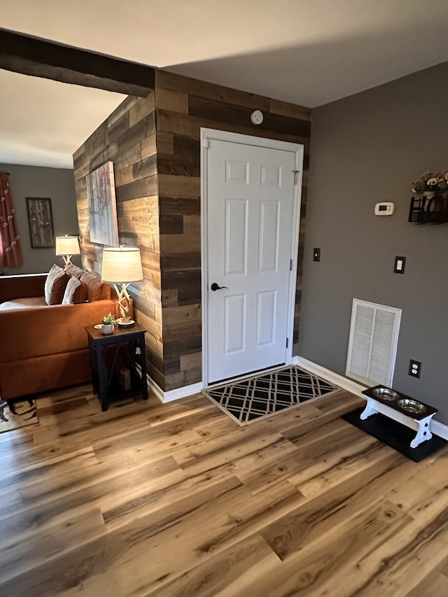 entrance foyer featuring wood walls and hardwood / wood-style flooring