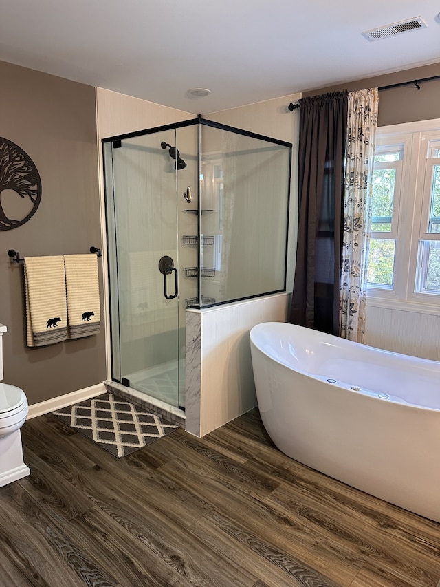 bathroom featuring toilet, independent shower and bath, and hardwood / wood-style flooring