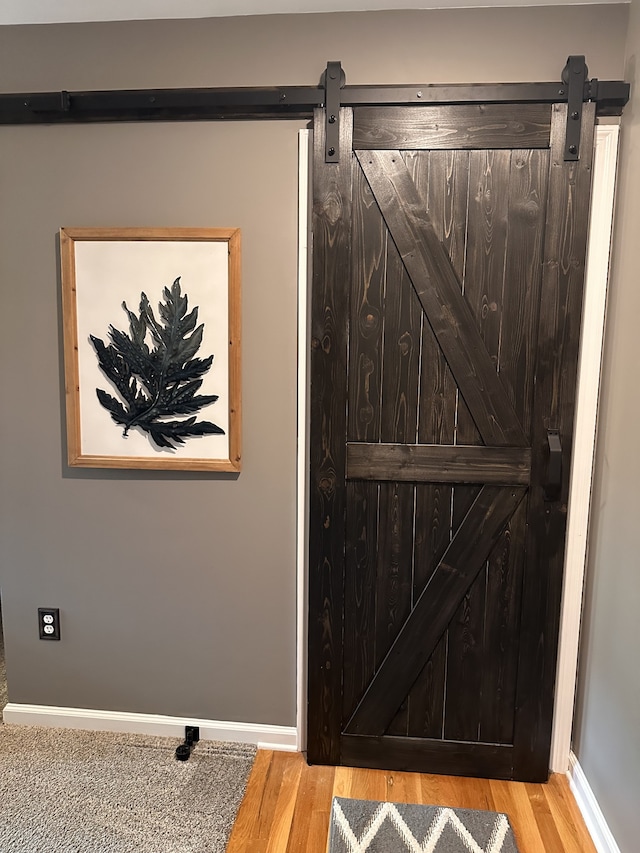 room details with a barn door and hardwood / wood-style flooring