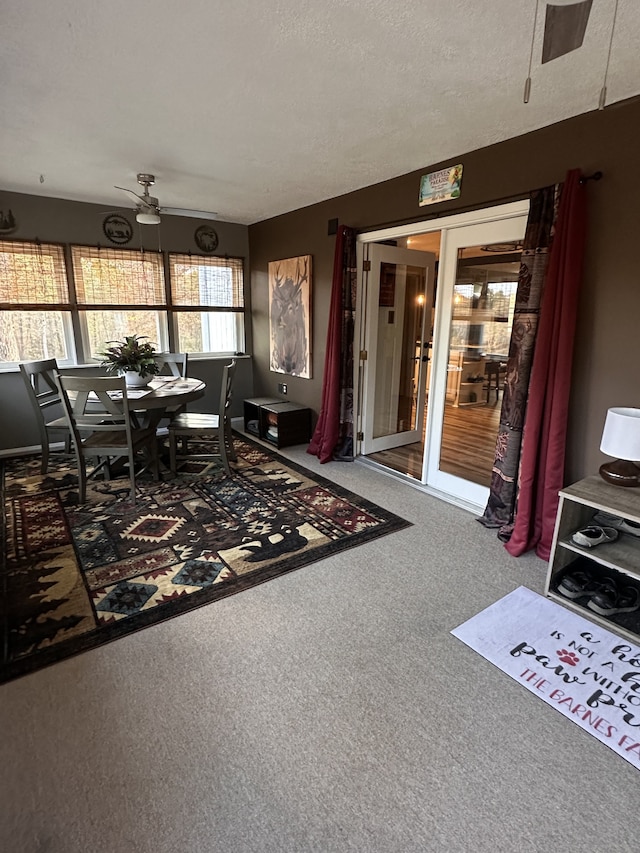 interior space featuring ceiling fan, a textured ceiling, and carpet floors