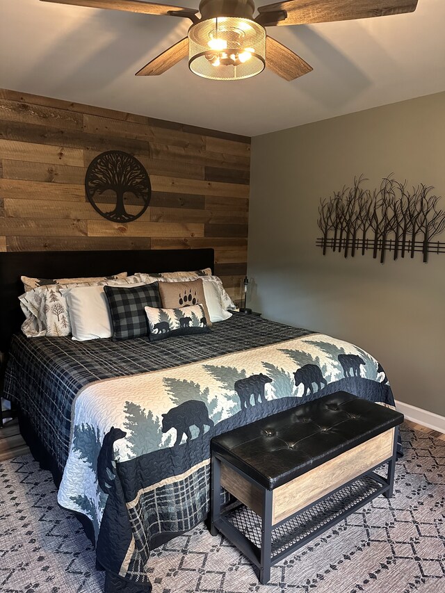 bedroom featuring wood walls and ceiling fan