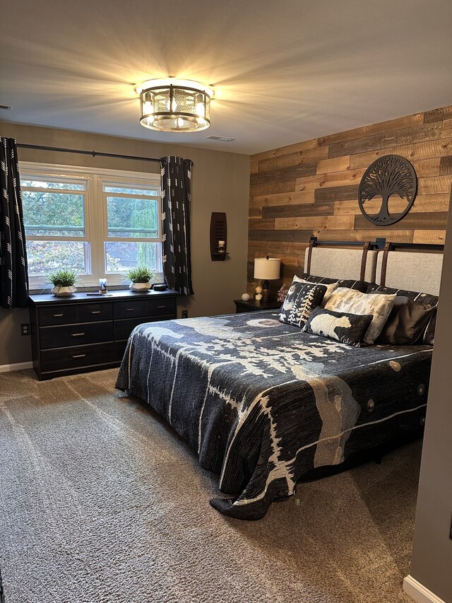 carpeted bedroom featuring wooden walls