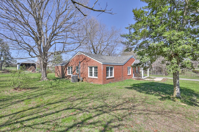 view of side of property featuring a lawn and a carport