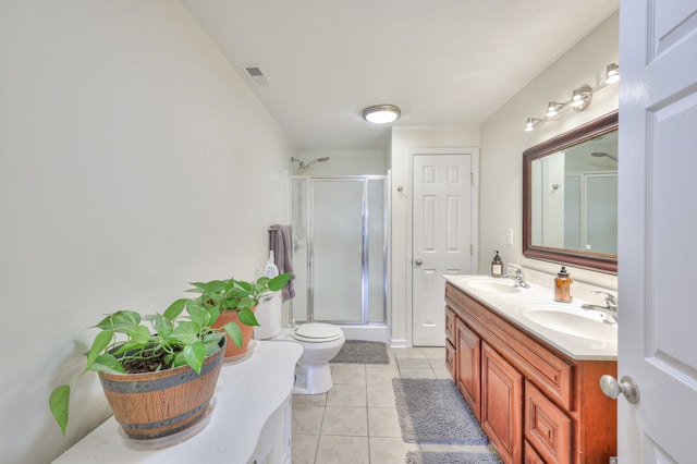 bathroom with toilet, vanity, tile patterned flooring, and a shower with door