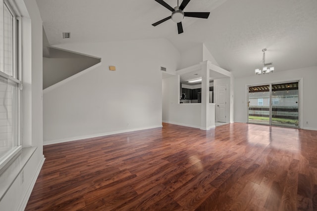 unfurnished living room featuring ceiling fan with notable chandelier, a textured ceiling, dark hardwood / wood-style floors, and high vaulted ceiling