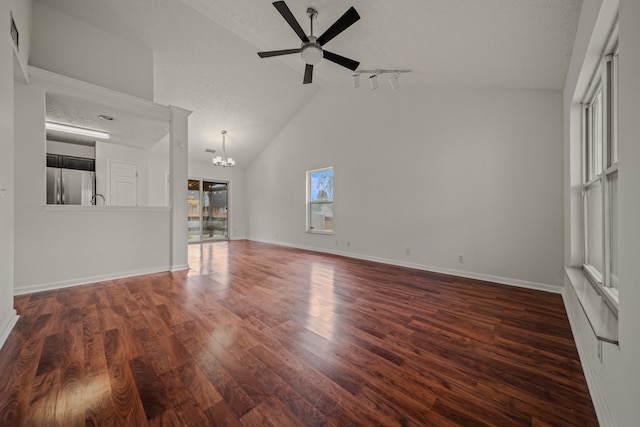 unfurnished living room with dark hardwood / wood-style floors, a textured ceiling, ceiling fan with notable chandelier, and high vaulted ceiling