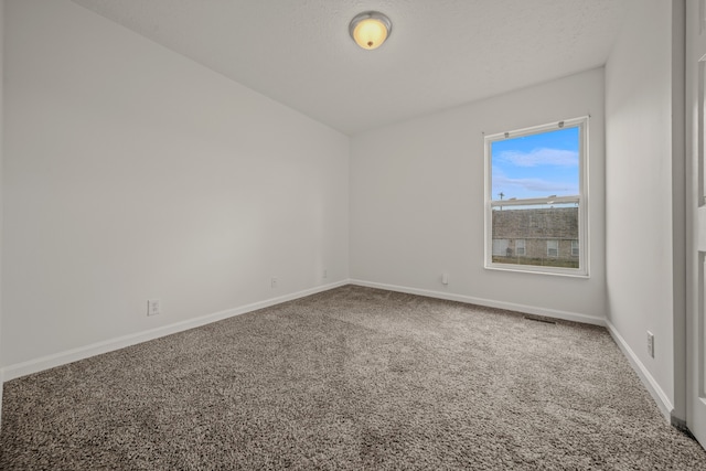 empty room with carpet and a textured ceiling