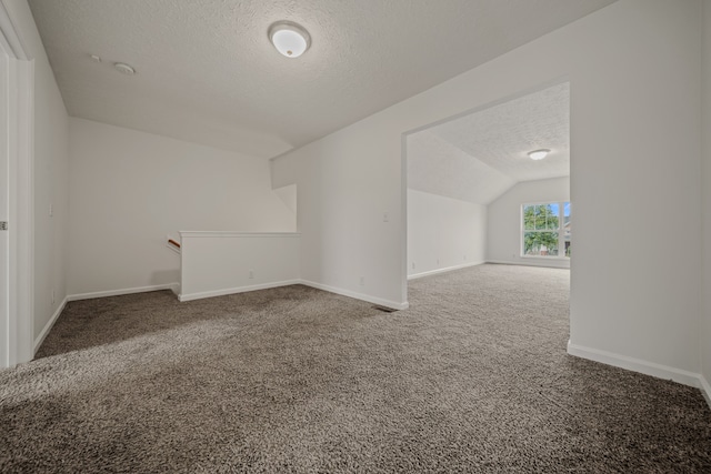 bonus room with a textured ceiling, carpet flooring, and lofted ceiling