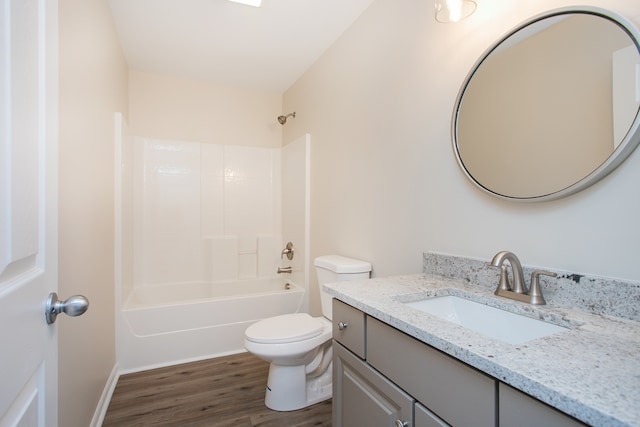 full bathroom with vanity, hardwood / wood-style flooring, washtub / shower combination, and toilet