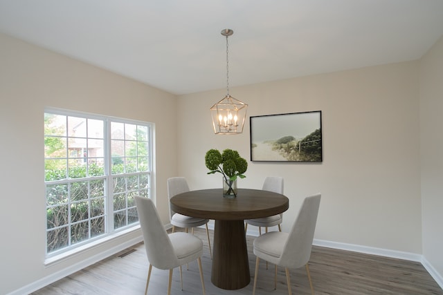 dining area featuring dark wood-type flooring and a notable chandelier