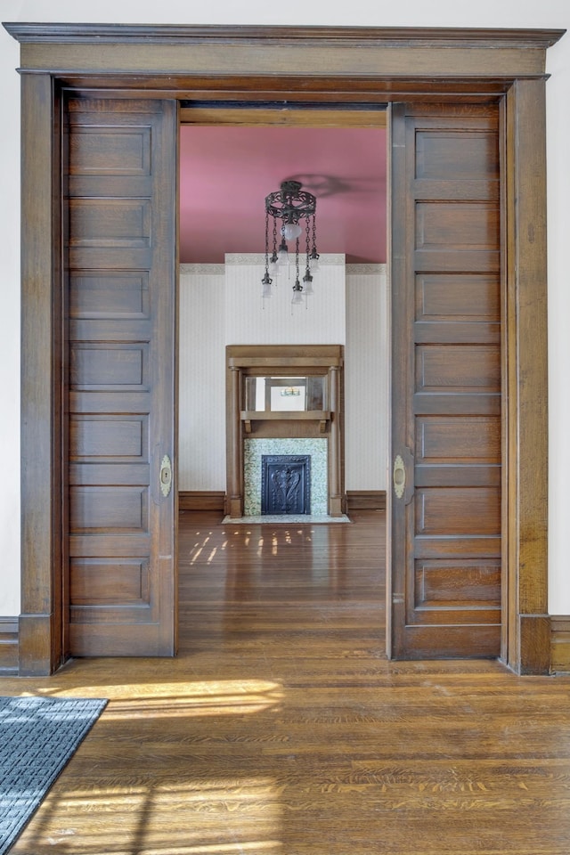 unfurnished living room featuring a chandelier and hardwood / wood-style floors