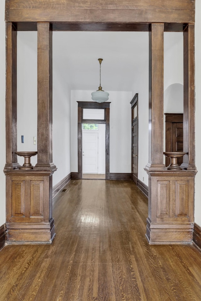 foyer entrance with dark hardwood / wood-style floors and ornate columns