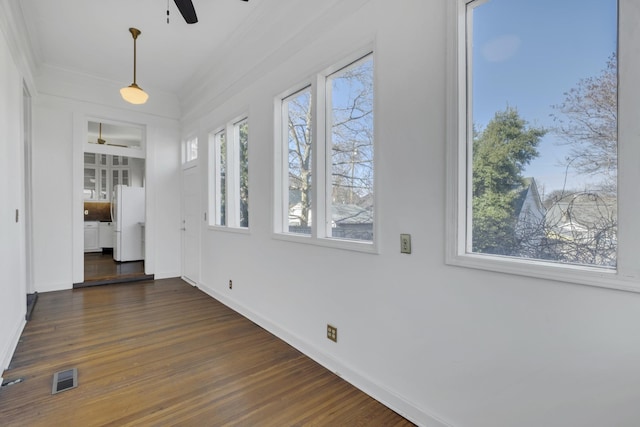 interior space with crown molding, ceiling fan, and dark hardwood / wood-style flooring