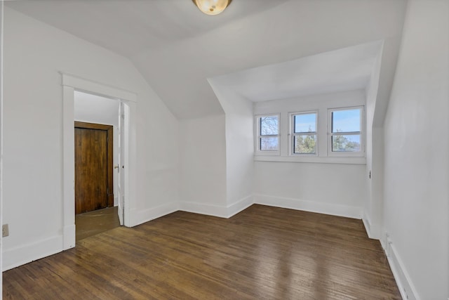 additional living space with vaulted ceiling and dark wood-type flooring