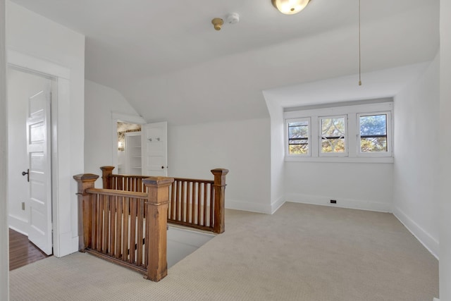 bonus room with vaulted ceiling and carpet