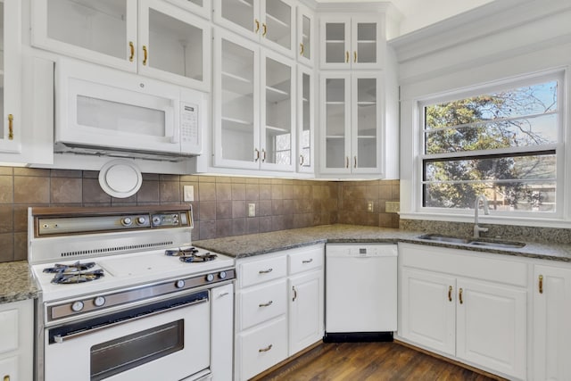 kitchen with white cabinetry, white appliances, sink, and dark stone countertops