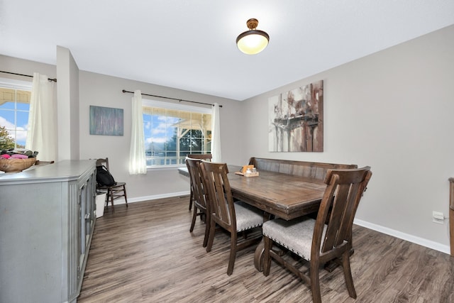 dining room featuring dark wood-type flooring and a healthy amount of sunlight