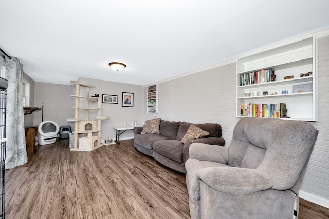 living room featuring brick wall and hardwood / wood-style flooring