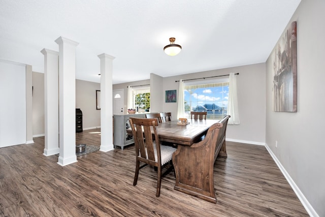 dining space featuring ornate columns and dark wood-type flooring