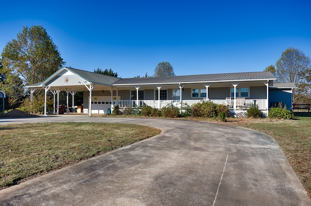 view of front of house featuring a front lawn, a garage, a carport, and a porch