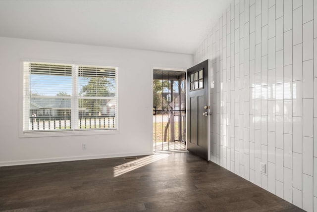 interior space with dark hardwood / wood-style flooring and vaulted ceiling