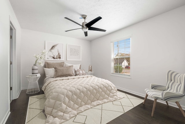 bedroom with hardwood / wood-style flooring, ceiling fan, and a textured ceiling