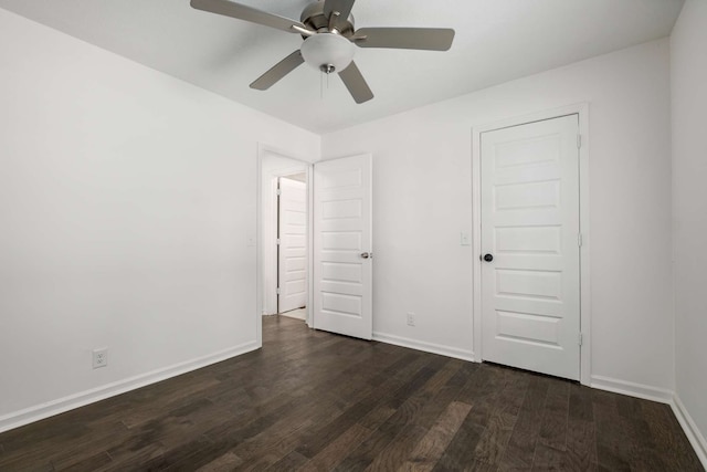 unfurnished bedroom with dark hardwood / wood-style flooring, a closet, and ceiling fan