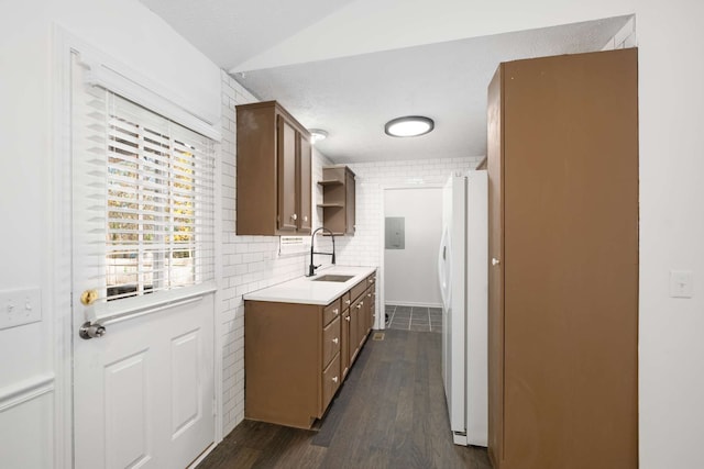 kitchen featuring brick wall, sink, white refrigerator, and dark hardwood / wood-style flooring