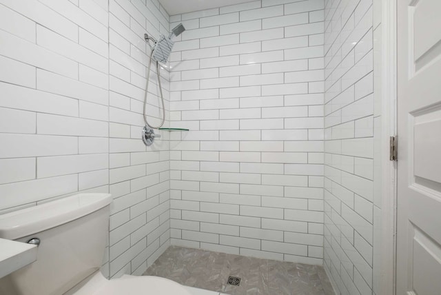 bathroom with tiled shower and toilet