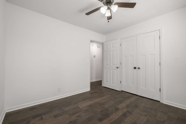 unfurnished bedroom with dark wood-type flooring, ceiling fan, and a closet