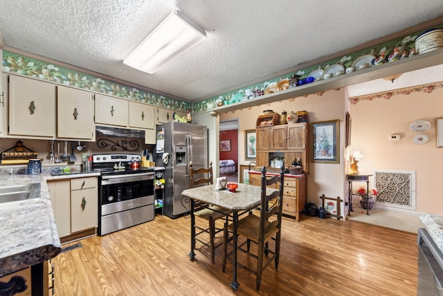 kitchen featuring appliances with stainless steel finishes, a textured ceiling, and light hardwood / wood-style flooring