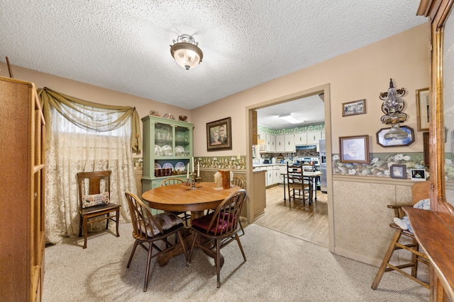 carpeted dining space featuring a textured ceiling