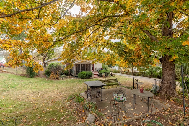 view of yard featuring a sunroom and a patio area