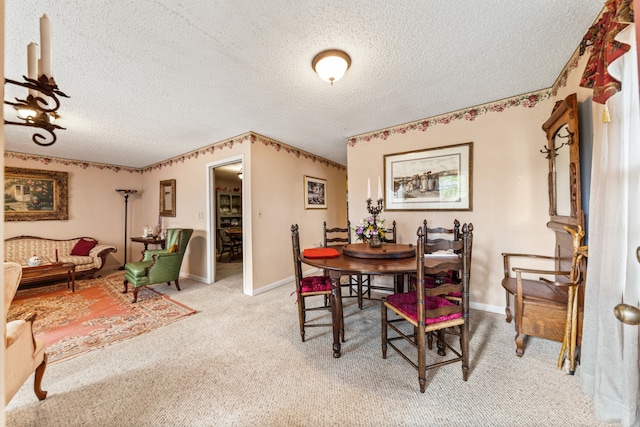 carpeted dining room featuring a textured ceiling