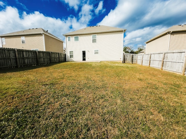 rear view of property with a yard