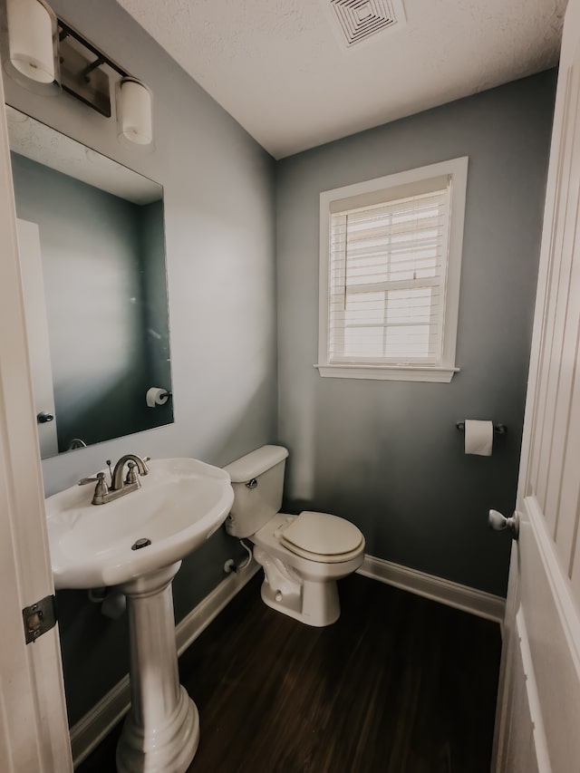 bathroom with toilet and wood-type flooring